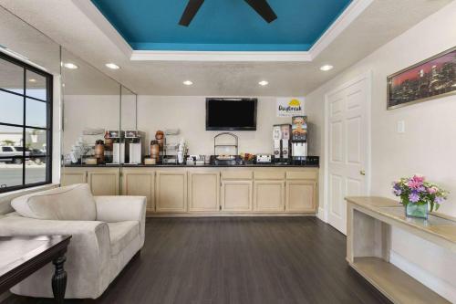 ein Wohnzimmer mit Sofa und Fernseher in der Unterkunft Days Inn by Wyndham Downey in Downey