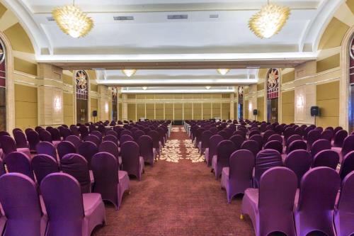 an empty room with purple chairs in a building at Wyndham Surabaya in Surabaya