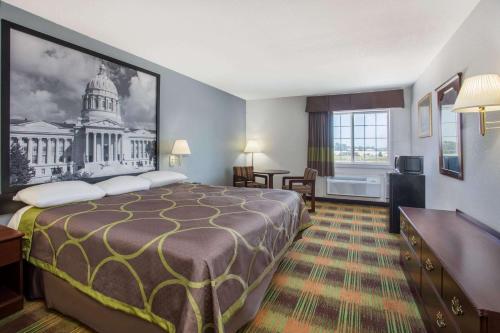 a hotel room with a large bed and a building at Super 8 by Wyndham Sweet Springs in Sweet Springs