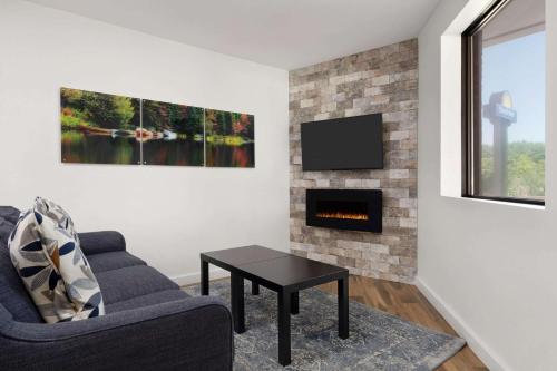 a living room with a couch and a fireplace at Days Inn by Wyndham Sarnia Harbourfront in Sarnia