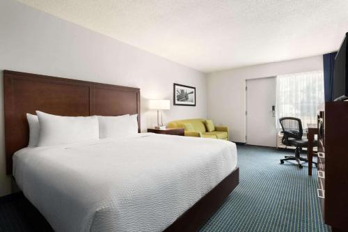 a hotel room with a large bed and a desk at Days Inn by Wyndham Sarnia Harbourfront in Sarnia