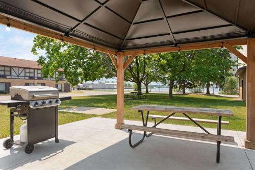 a picnic table and a grill and a picnic bench at Days Inn by Wyndham Sarnia Harbourfront in Sarnia