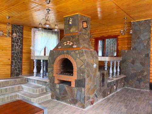 a large stone fireplace in a room in a cabin at Бердо-Хауз in Delyatyn