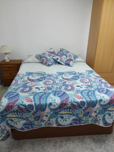 バルベルデにあるApartamento Perezのベッド(カラフルな毛布、枕付)