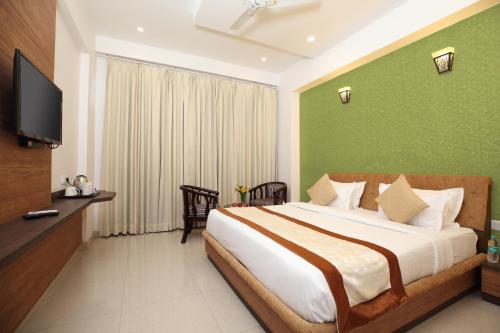 a bedroom with a bed with a green wall at Genx Crescent Lucknow in Lucknow