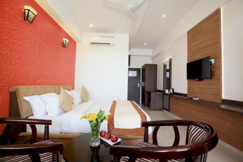a hotel room with a bed and a table and chairs at Genx Crescent Lucknow in Lucknow