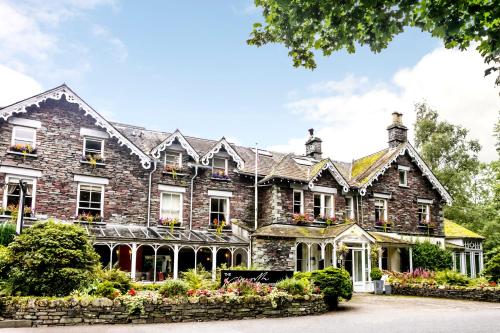 een groot bakstenen gebouw met bloemen ervoor bij The Wordsworth Hotel in Grasmere