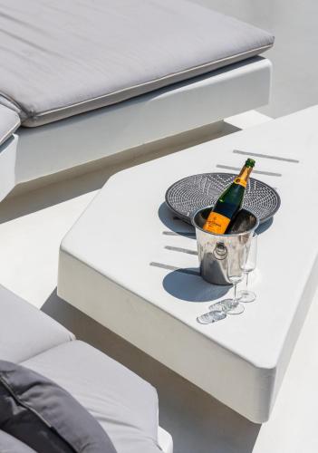 a bottle of champagne in a bucket on a bed at Villa Artisti Mykonos in Agrari