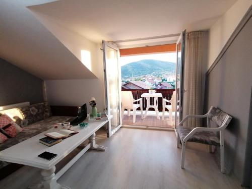 a living room with a couch and a table and a window at Apartman Panorama Arandjelovac in Arandjelovac