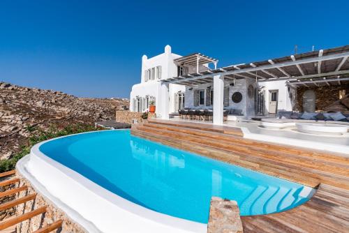 a swimming pool in front of a house at Villa Artisti Mykonos in Agrari