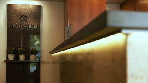 a lobby with potted plants on a shelf and a door at Hotel Castle Garden in Budapest