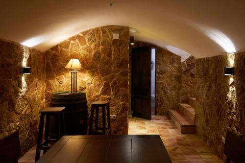 Racó D Onil في Onil: غرفة مع طاولة وكراسي على جدار حجري