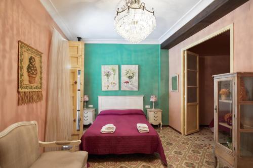 a bedroom with a purple bed and a chandelier at Racó D Onil in Onil