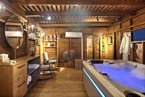 a bathroom with a tub in a room with wooden walls at אחוזה בהרים in Meron