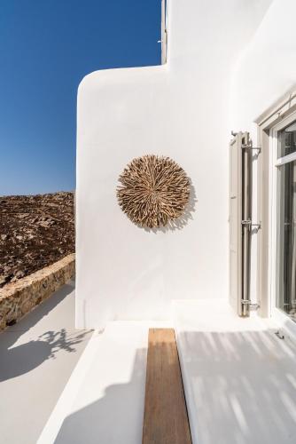 a white wall with a sculpture on the side of a building at Villa Artisti Mykonos in Agrari