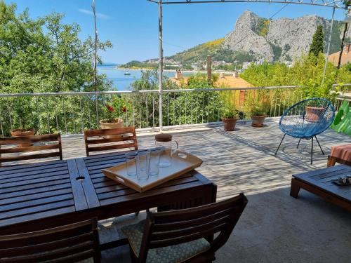 a patio with a table and chairs and a view of the water at Cozy apartments with seafront terraces in Omiš