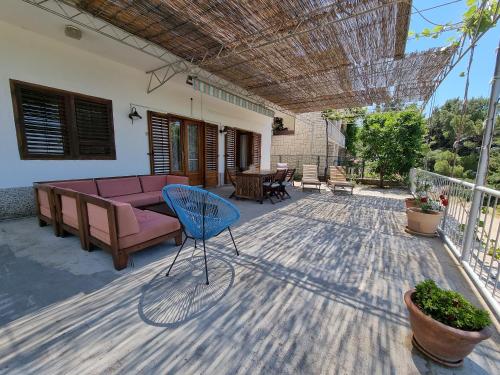 a patio with a couch and a chair on a deck at Cozy apartments with seafront terraces in Omiš
