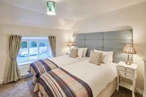 a bedroom with a large white bed and a window at Host & Stay - Willow Cottage in Helmsley