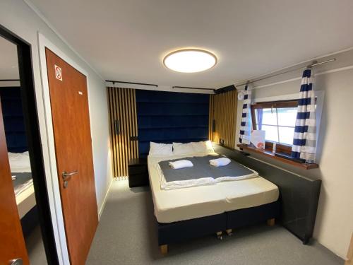 Dormitorio pequeño con cama con cabecero azul en The Boat - Hostel&Chill, en Cracovia