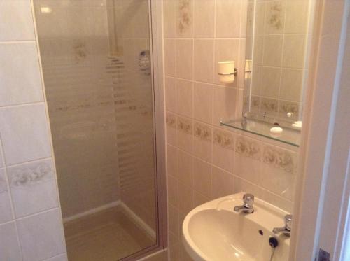 uma casa de banho com um chuveiro e um lavatório. em Legends Hotel em Blackpool