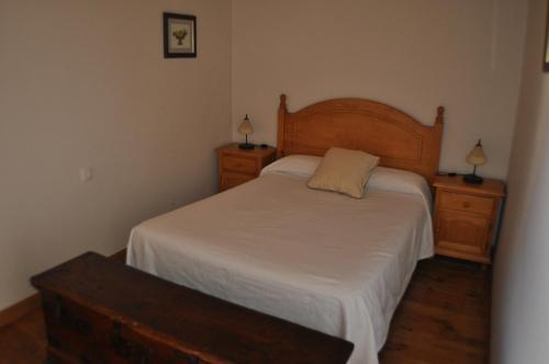 HoyocaseroにあるCasa Rural los 5 Balconesのベッドルーム1室(ベッド1台、ドレッサー2台、ランプ2つ付)