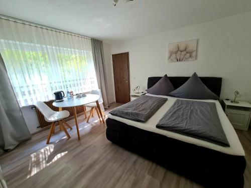 a bedroom with a large bed and a table at Pension Villaggio in Mertesheim