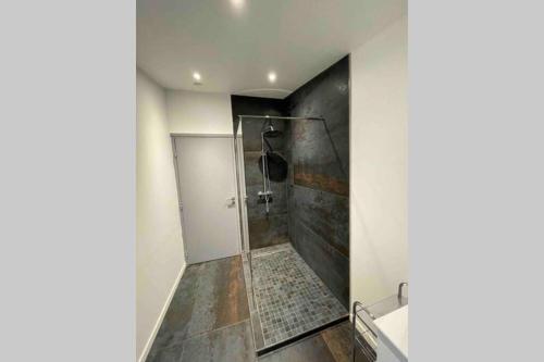 une salle de bain avec une douche avec une porte vitrée dans l'établissement Le gîte d Olhain2, à Gauchin-Légal