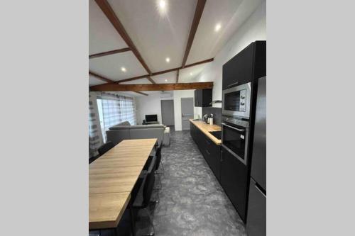 une cuisine avec des armoires noires et un comptoir en bois dans l'établissement Le gîte d Olhain2, à Gauchin-Légal