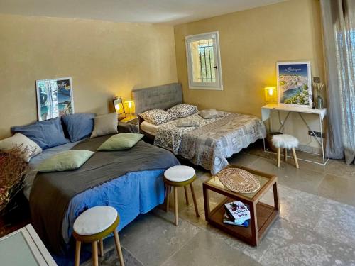 1 Schlafzimmer mit 2 Betten, 2 Tischen und Stühlen in der Unterkunft Studio Panoramic with the pool near Saint Victoire Aix en Provence in Le Tholonet