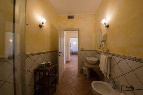 a bathroom with a sink and a toilet and a mirror at Hotel Scapolatiello in Cava deʼ Tirreni