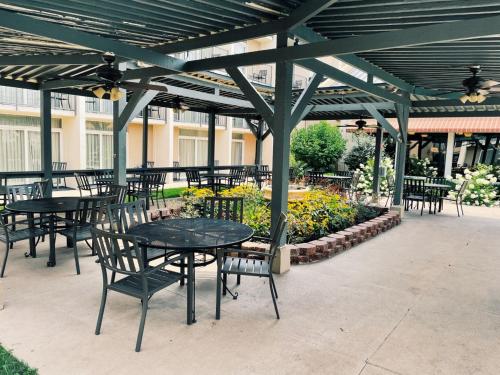 a group of tables and chairs under a pergola at Wyndham Garden Warsaw in Warsaw