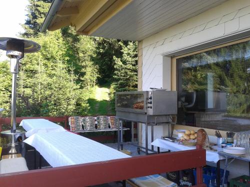 an outdoor kitchen with a grill on a patio at Haus Brockenblick in Gehlberg