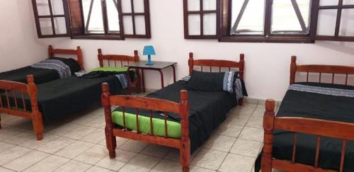 聖佛朗西斯科迪伊塔巴波阿納的住宿－Fazenda São Felipe，一间设有四张床和一张桌子及窗户的房间