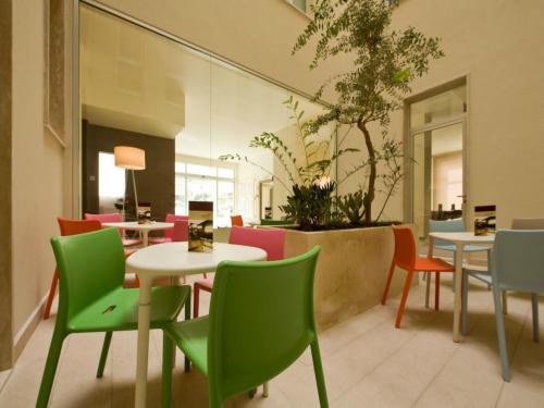 a restaurant with colorful chairs and tables in a building at Eos Hotel in Lecce