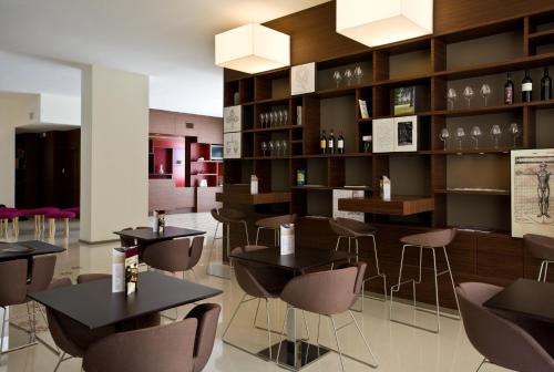 a restaurant with tables and chairs and a shelf of wine bottles at Eos Hotel in Lecce