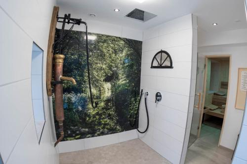 um chuveiro na casa de banho com uma pintura na parede em Zum Heuerling Ferienwohung Leinenstube mit Sauna em Versmold