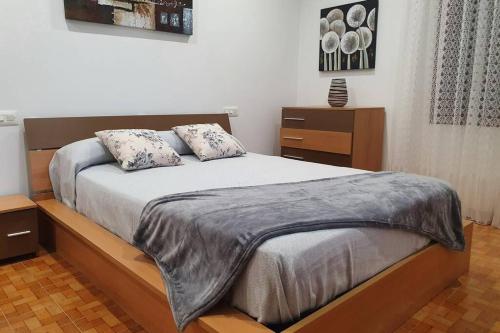 a bedroom with a bed with two pillows on it at Apartamento A Fontiña in Pontevedra