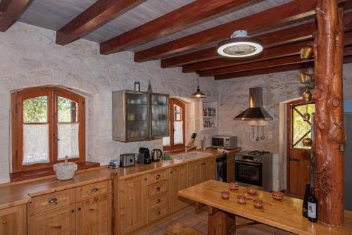 a kitchen with wooden cabinets and a wooden table at Wild Oak Estate - Stunning Views at a Dreamy Location, by ZanteWize in Argasi