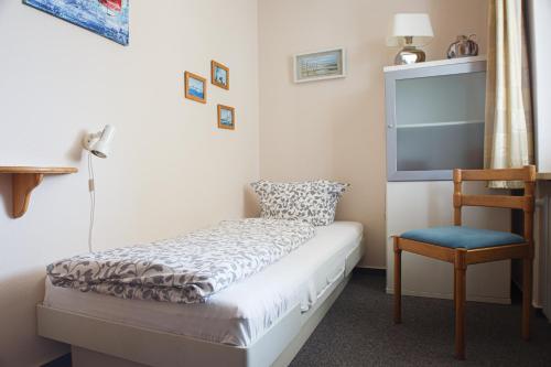 a small bedroom with a bed and a chair at Haus Uthlande Uthlande Whg 23 Lütte Bris in Wyk auf Föhr