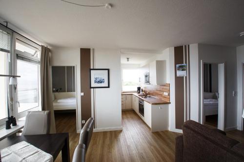 ein Wohnzimmer mit einer Küche und einem Esszimmer in der Unterkunft Haus Uthlande Uthlande Whg 52 Möwennest in Wyk auf Föhr