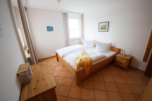 - une petite chambre avec un lit et une table dans l'établissement Haus Uthlande Uthlande Whg 11 Strandglück, à Wyk auf Föhr
