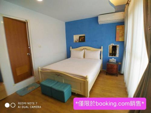 a bedroom with a bed with a blue wall at 玖拾捌民宿-98bnb in Hualien City
