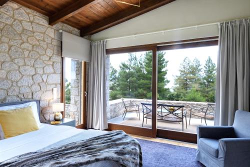 a bedroom with a bed and a balcony with a patio at Amfikleia Chalet in Amfikleia