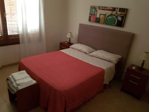 ein Schlafzimmer mit einem großen Bett mit einer roten Decke in der Unterkunft Casa Esquina - Barrio Palermo - Zona Anfiteatro in Villa María