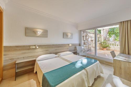 ein Hotelzimmer mit einem Bett und einem großen Fenster in der Unterkunft Apartamentos Ben-Hur in Playa de Palma