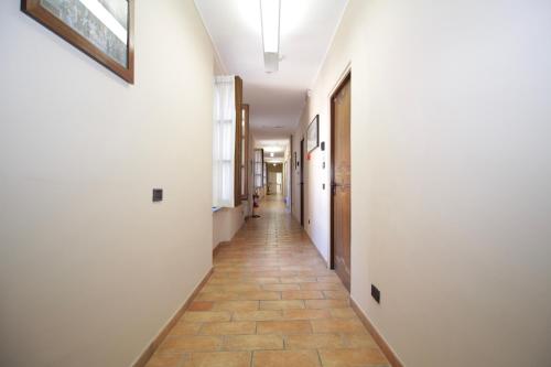 a hallway with white walls and a tile floor at Hotel Tornielli 9 by LVG Hotel Collection in Novara