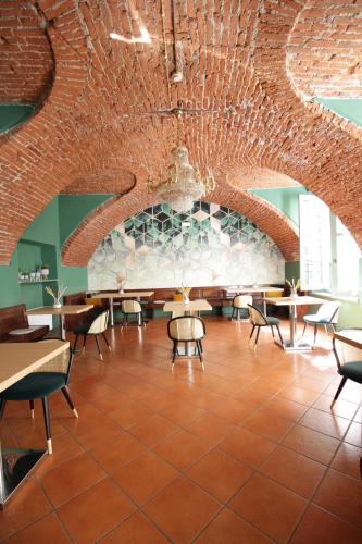 a restaurant with a brick ceiling and tables and chairs at Hotel Tornielli 9 by LVG Hotel Collection in Novara
