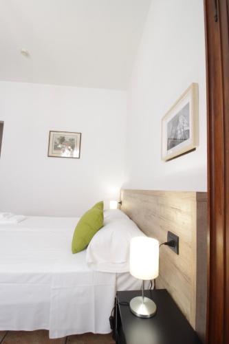 a bedroom with a white bed and a lamp at Hotel Tornielli 9 by LVG Hotel Collection in Novara