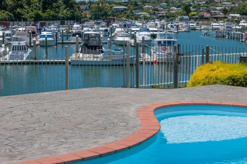 a swimming pool next to a marina with boats at Beachcomber Inn Picton in Picton