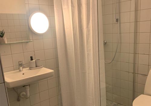 y baño blanco con lavabo y ducha. en Camp Femern Bælt, en Søllested